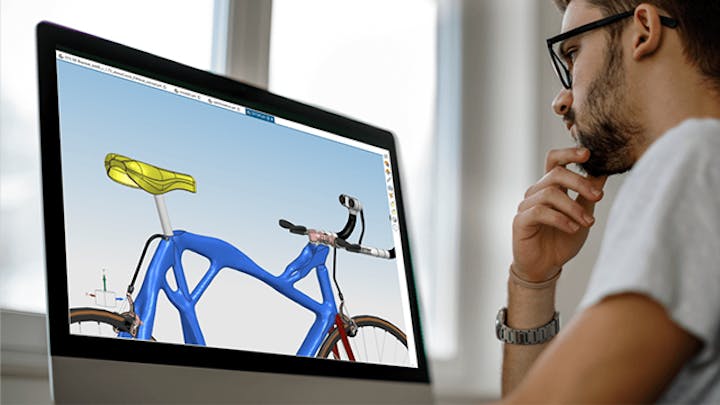 An engineer looking at a bike design simulation on a screen.