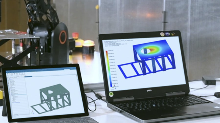 A couple of laptops in a test center displaying Simcenter 3D™ software integrating simulation and test engineering to enhance each other.