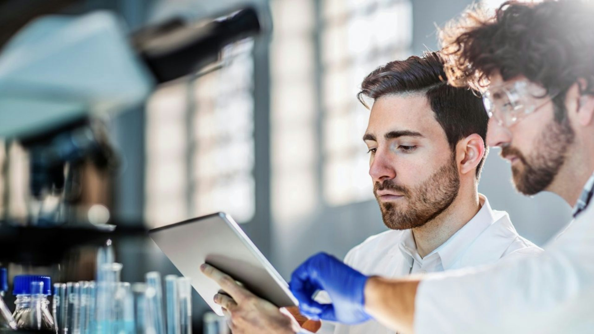 Two people working on a tablet.