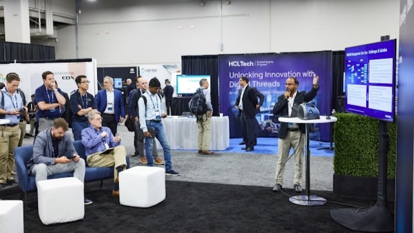 A Siemens partner stands in front of group in a Realize LIVE Knowledge Theater.