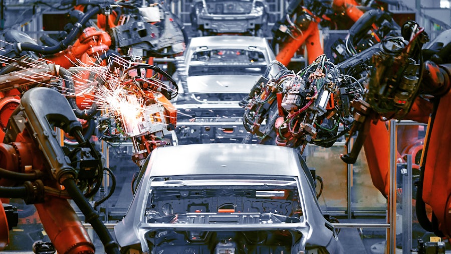 Robotic arms on an automotive assembly line welding together parts onto vehicle bodies.