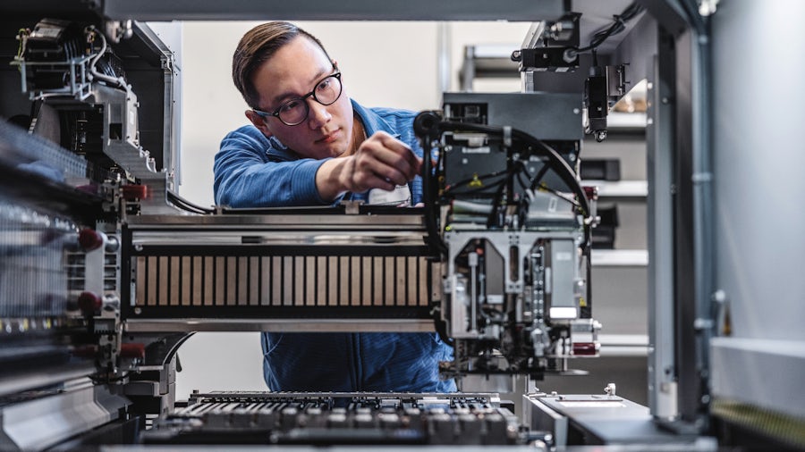 A service technician performs routine maintenance on an industrial machine.