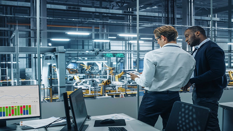 Two automotive professionals analyzing application portfolio management tool