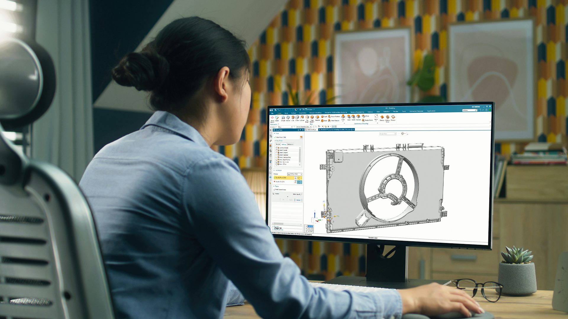 Designer looking at a computer screen showing NX for CAD.