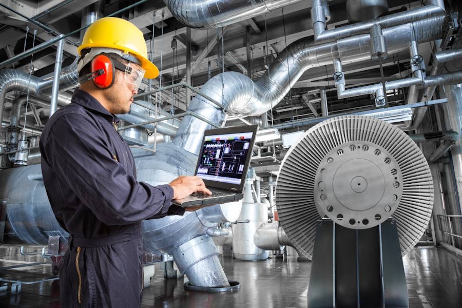 An engineer using simulation software on laptop in thermal power plant factory