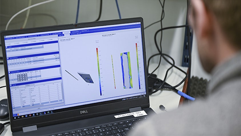 Osoba používající řešení Simcenter pro lokalizaci zdroje zvuku na notebooku.