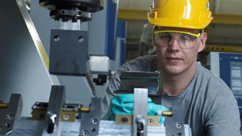 Man in a hardhat working a machine in a factory