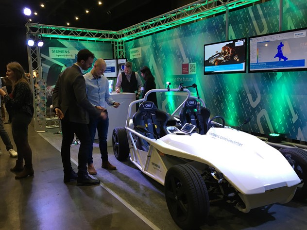 Dos personas examinan un coche de concepto expuesto en una convención.