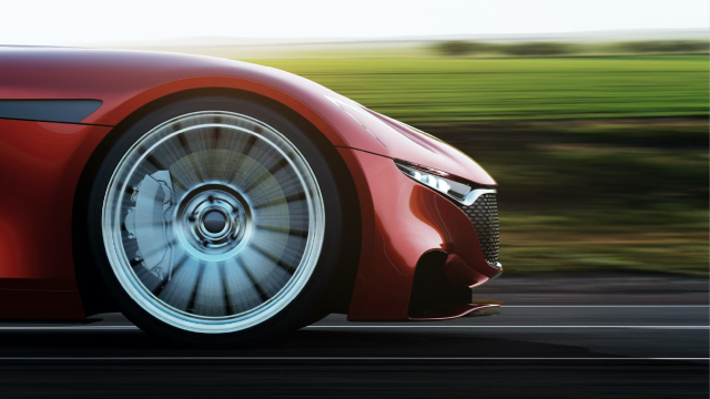 The front wheel of a sportscar driving on the road