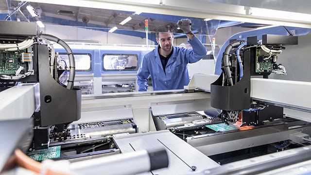 A factory employee working on an electronics manufacturing execution system.