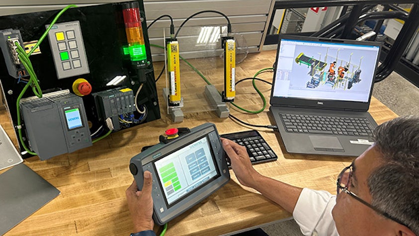 Engineer with an HMI, a PLC and process simulation software conducting virtual commissioning.