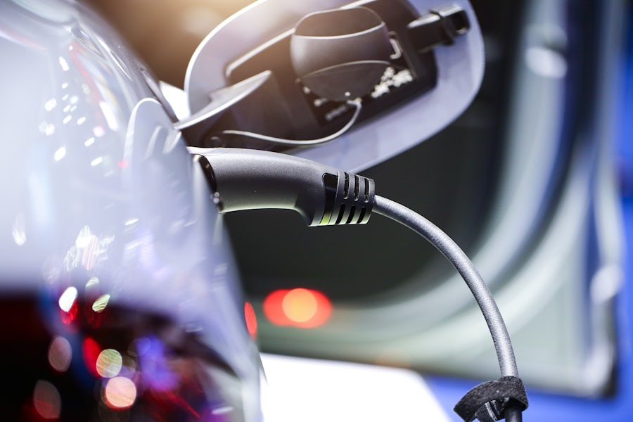 Close-up photo of a charging cable plugged into an electric vehicle.