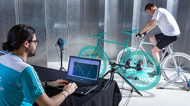Man using digital image correlation (DIC) to measure 3D full-field data of a bicycle.