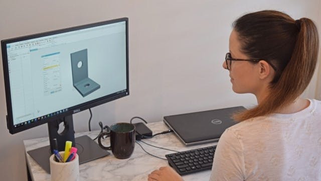 A female student on her computer with an NX CAD part design open