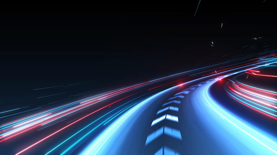 A futuristic road lit up in neon curves outward, suggesting a forward path to an electric vehicle future