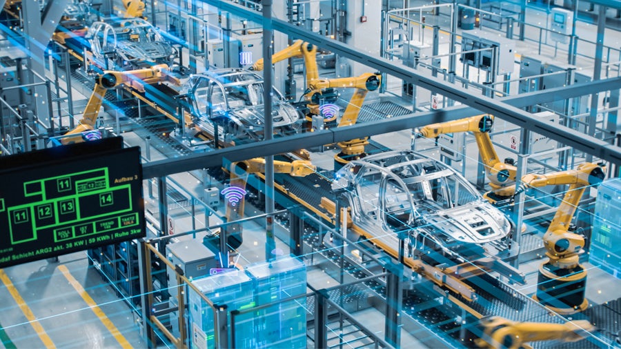 Automated robot arm assembly line manufacturing high-tech electric vehicles.