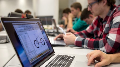Students working on an R&D project on their laptops in a lecture hall