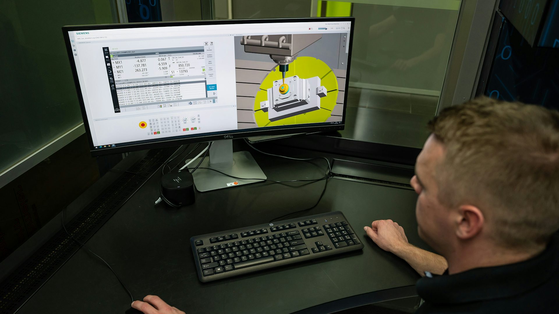 Man sitting at his desk looking at two computer monitors. 