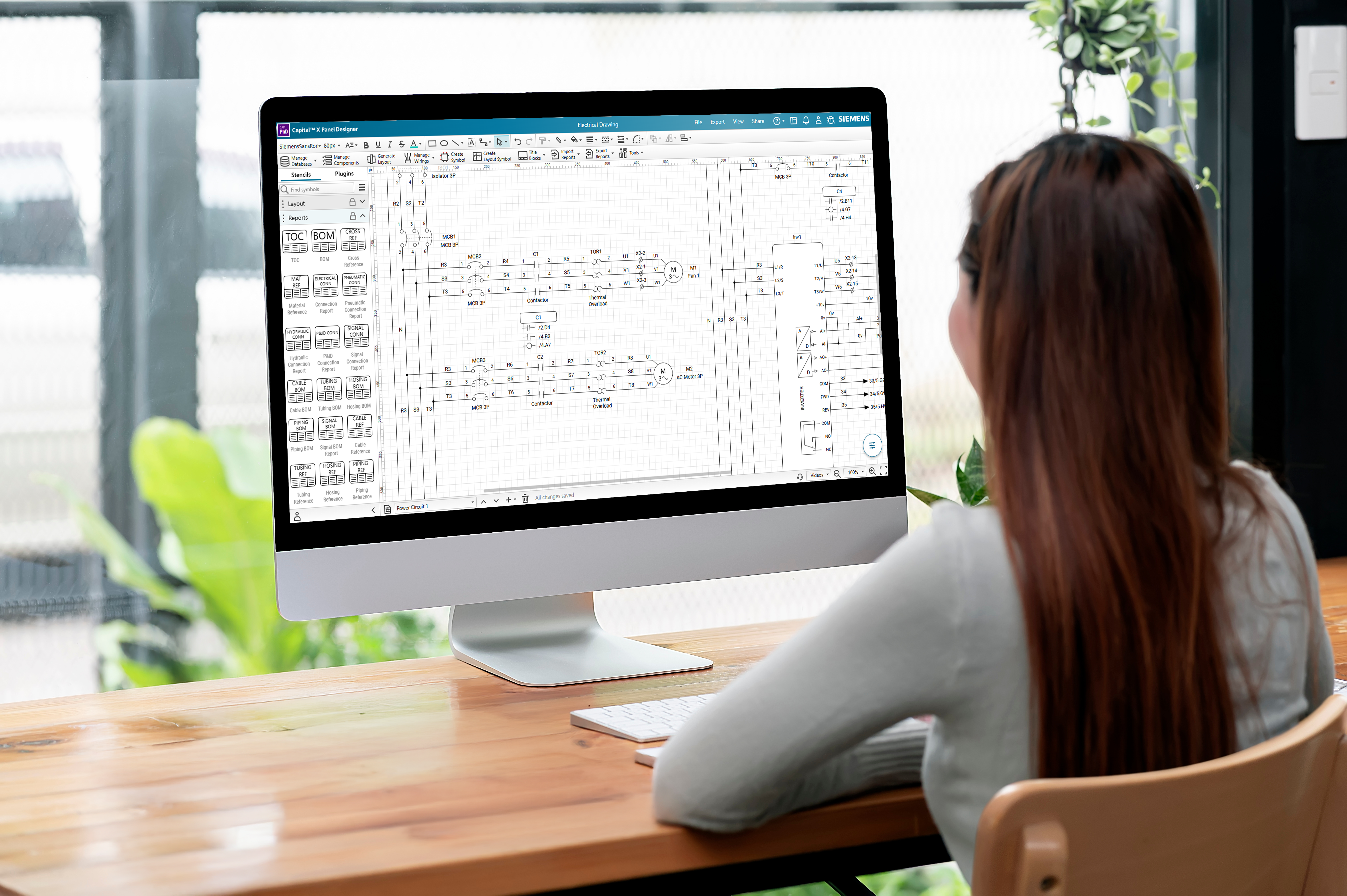 The electrical engineer is using Capital X Panel Designer with a monitor screen. 