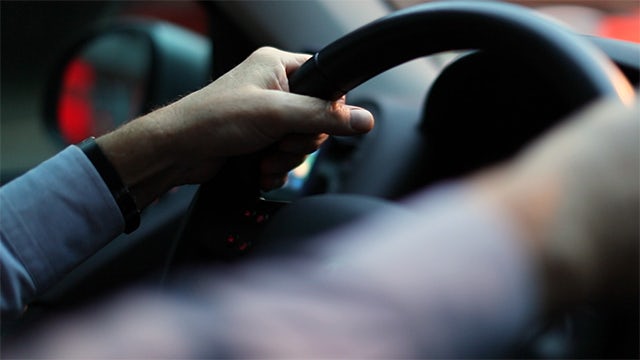 Two hands grabbing a steering wheel