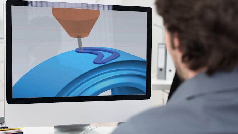 An engineer looks at a simulation of additive manufacturing on his computer.