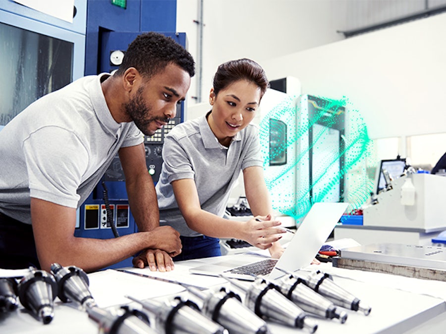 Dos trabajadores de una pequeña empresa manufacturera utilizan un software de fabricación digital para visualizar el desarrollo del producto