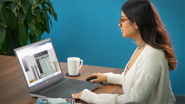 A woman sitting at a table working on her laptop.