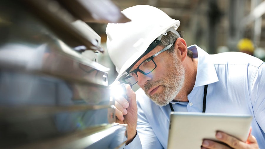 Man looking at equipment in a manufacturing facility