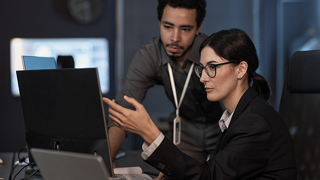 colleagues reviewing report on laptop