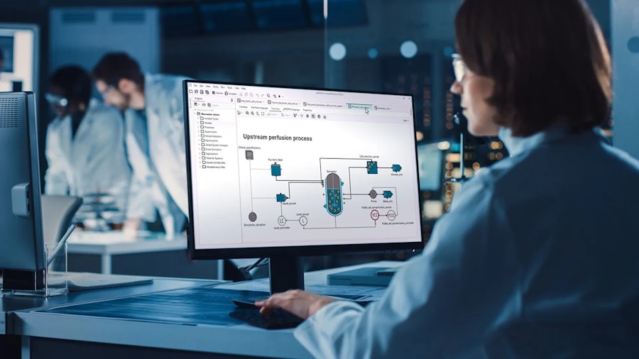 A scientist sitting at a computer using pharmaceutical software.