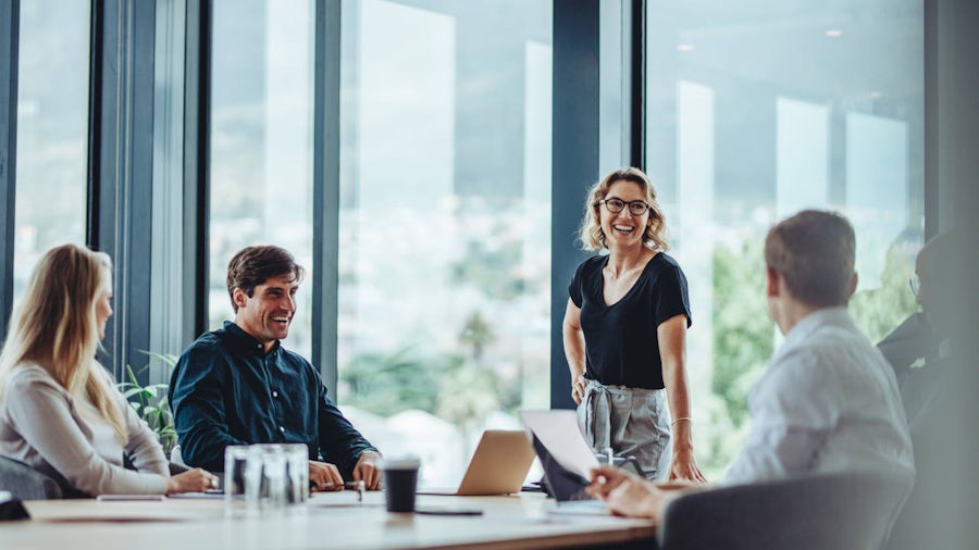 A blurred presenter standing next to a flipchart in front of a group of people 