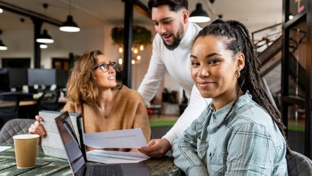 3 students in a library working on homework