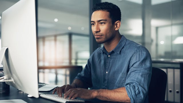 コンピューターで作業する男性。