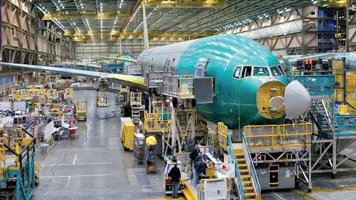Workers perform work on an airplane on the shop floor