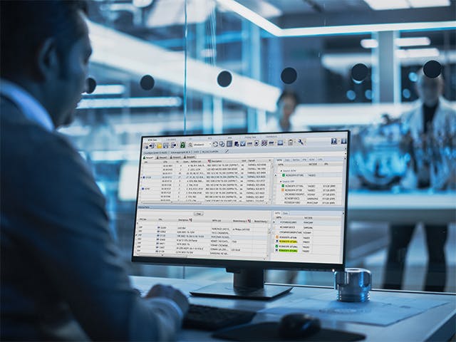 Man looking at a computer showing a screen shot of the Process Preparation X BOM Connector which is used to read the Bill of Materials and map to parts available in the warehous or that need to be sourced from material suppliers