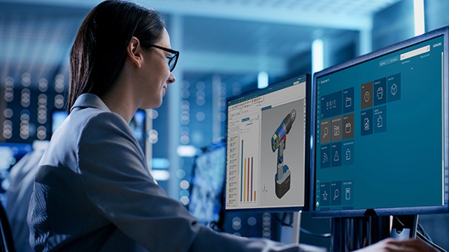 モニターにTeamcenter Xが表示されているコンピューターを見ている女性