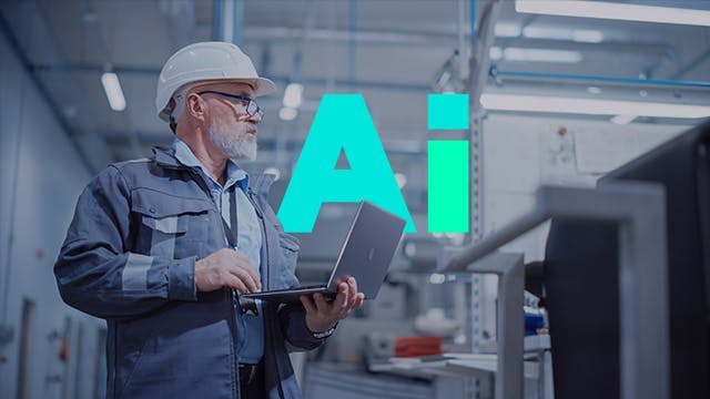 Man holding a laptop in a factory facility.