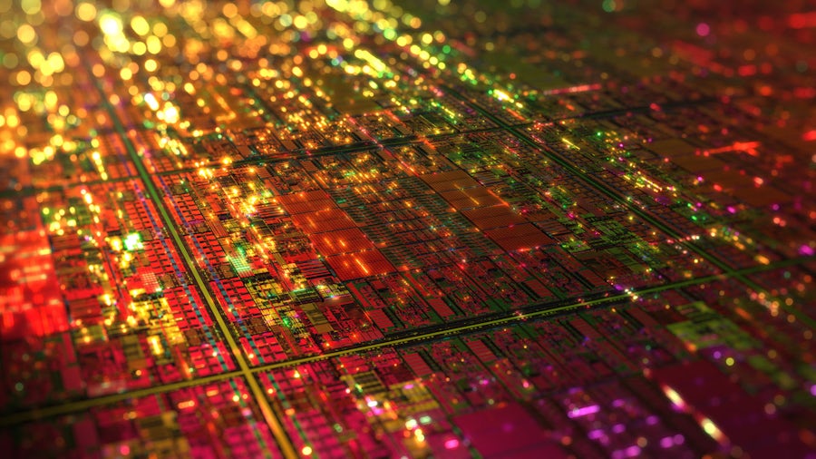 A vibrant, close-up illustration of a silicon microchip layout, showing a complex network of interconnected circuits and structures in red, yellow and green hues, highlighting the intricate architecture and density of modern semiconductor designs.