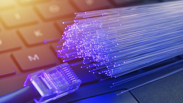 Optical fiber connections displayed over a computer keyboard.