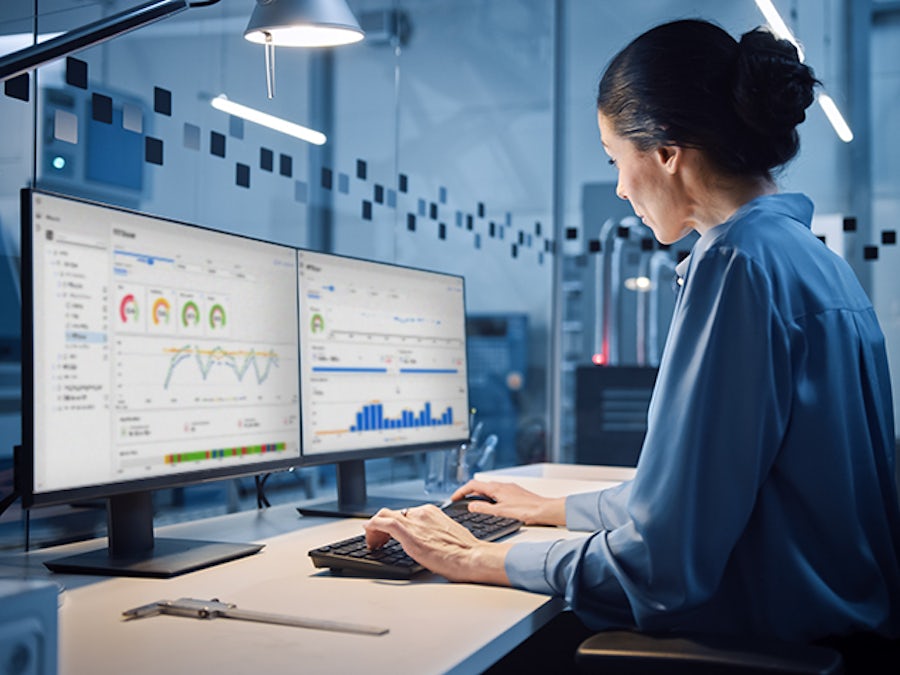 Women sitting at a desk with two computer screens