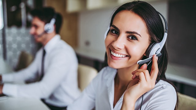 Support center employees communicate with customers via headsets.