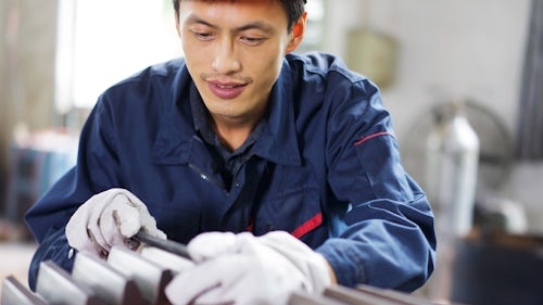 worker performing a quality management inspection in a manufacturing plant