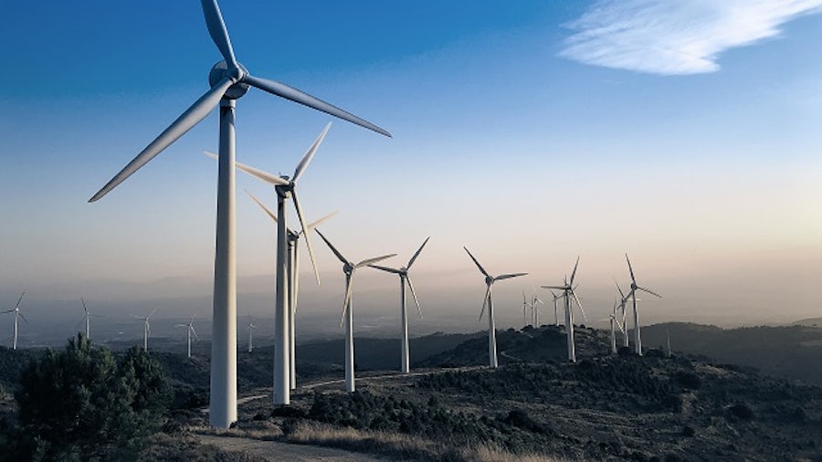 Wind farm at dusk in a desert environment.