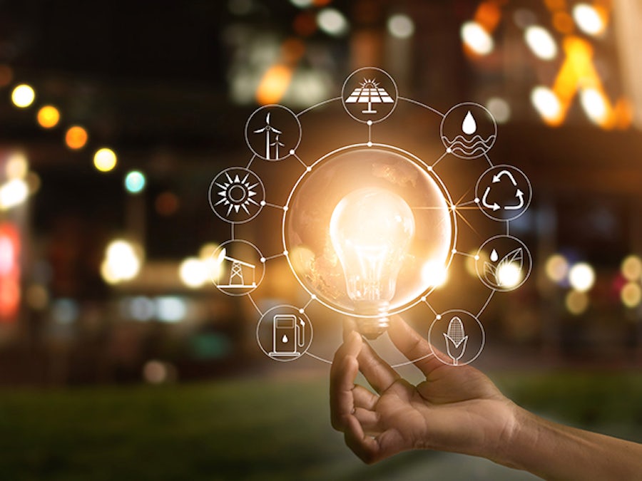 Photo of a light bulb being held with icons surrounding it