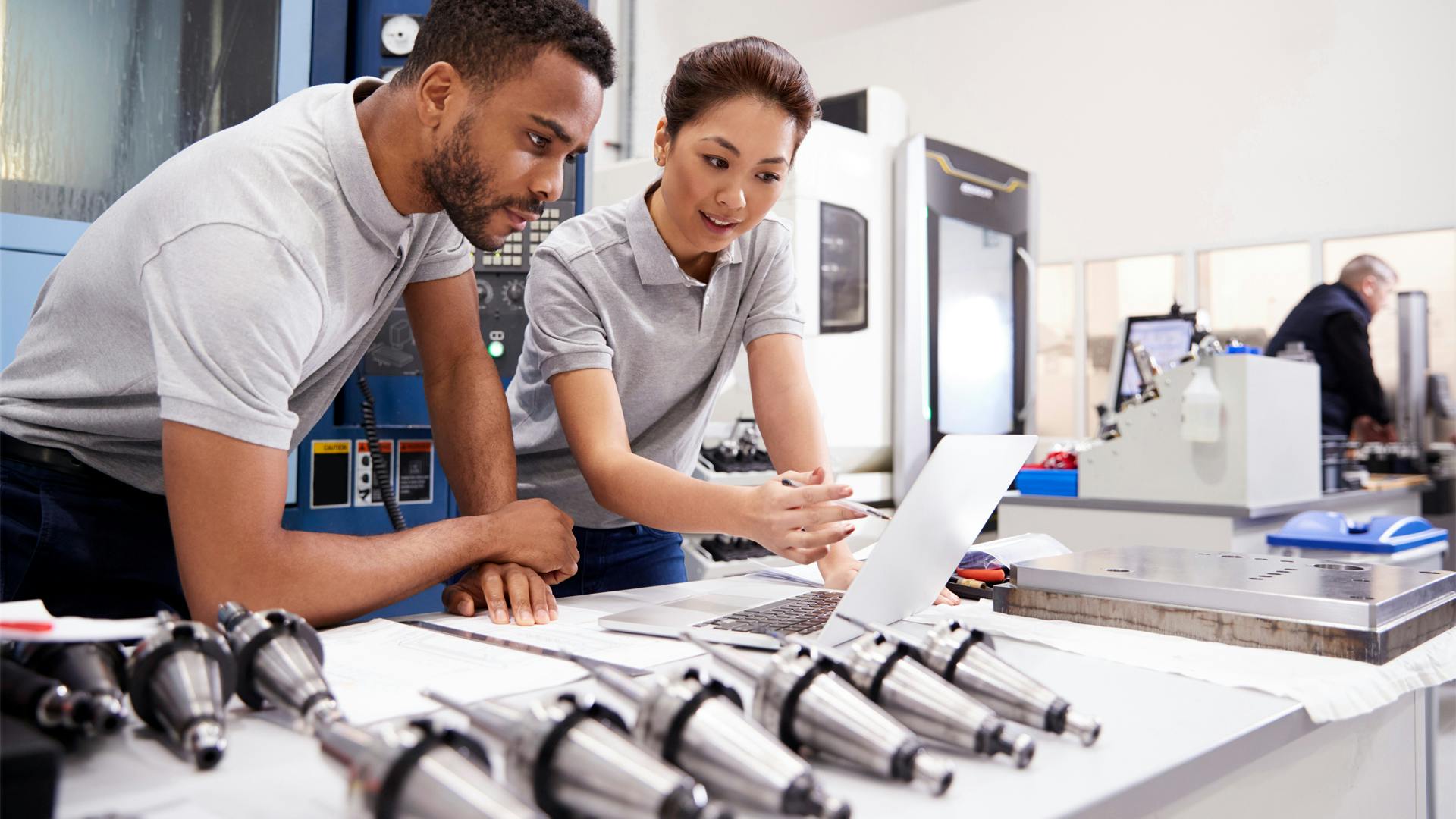Two quality engineers review the quality of parts using a digital quality management solution.
