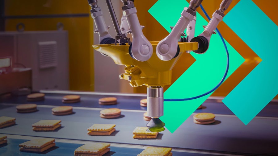 Brazo robótico automatizado que coloca galletas en la cinta transportadora de una fábrica moderna.