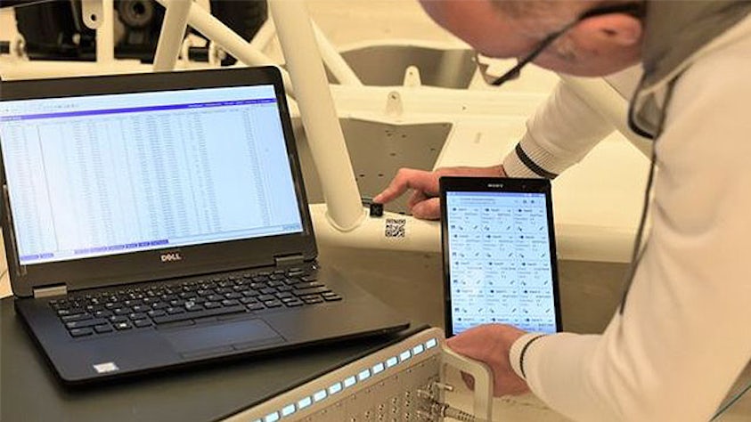 Inženýr provádí test na notebooku a tabletu.