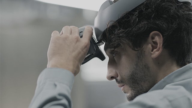 Close up of a person wearing the Sony head-mounted display (HMD) VR headset.