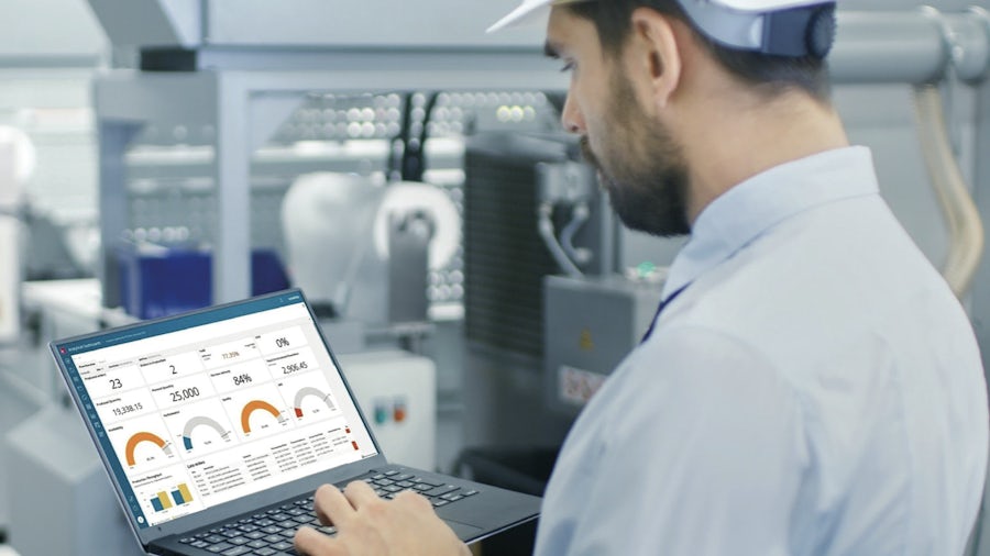 Manufacturing working using a lap top to view performance data in Opcenter Intelligence Cloud