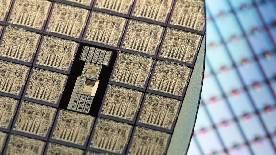 a close up of a silicon wafer with grid background